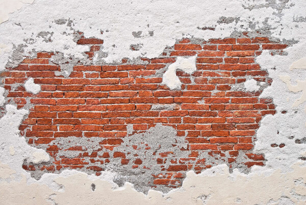 Red bricks peaking through white stucco wall by Gabriele Diwald on Unsplash